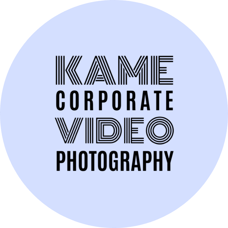 Rundes Logo mit der Aufschrift „KAME Corporate Video Photography“ in schwarzer Typografie auf hellblauem Hintergrund.